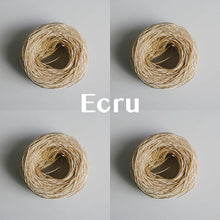Load image into Gallery viewer, Four yarn cakes of 4-ply mercerised cotton yarn in ecru packaged in a compostable plastic bag and an Oxford Weaving Studio sticker