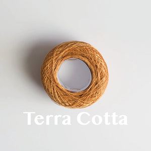 A 'Terra Cotta' colour yarn cake of 2/16s mercerised cotton yarn