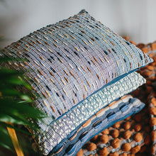 Load image into Gallery viewer, A stack of handwoven cushions by Cassandra Smith featuring beautiful yarn textures in blues, creams, greys and brown.