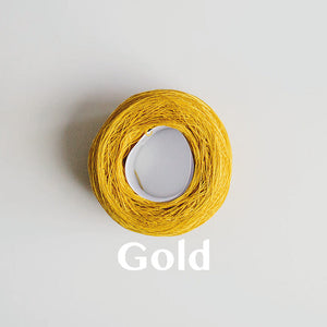 A 'Gold' colour yarn cake of 2/16s mercerised cotton yarn