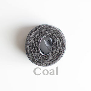 A 'Coal' colour yarn cake of 2/17s merino lambswool yarn