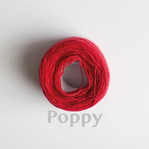 A 'Poppy' colour yarn cake of 2/17s merino lambswool yarn