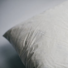 Load image into Gallery viewer, A close up of the corner of a duck-filled cushion pad covered in cotton cambray fabric.