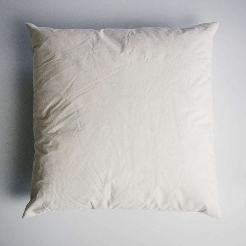 A square 14 inch by 14 inch duck-filled cushion pad covered in cotton cambray fabric.