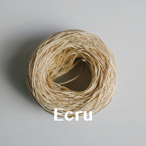 One yarn cake of 4-ply mercerised cotton yarn in ecru packaged in a compostable plastic bag and an Oxford Weaving Studio sticker