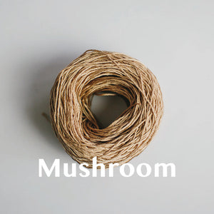 One yarn cake of 4-ply mercerised cotton yarn in mushroom packaged in a compostable plastic bag and an Oxford Weaving Studio sticker