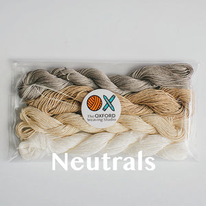 Four skeins of mercerised cotton yarn in neutral colours packaged in a compostable plastic bag and an Oxford Weaving Studio sticker