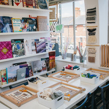 Load image into Gallery viewer, Display of weaving books and a table set up for a weaving workshop at The Oxford Weaving Studio