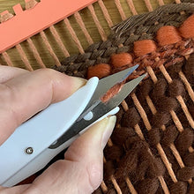 Load image into Gallery viewer, Detail of snips being used to trim yarn on the back of a woven wall-hanging at The Oxford Weaving Studio