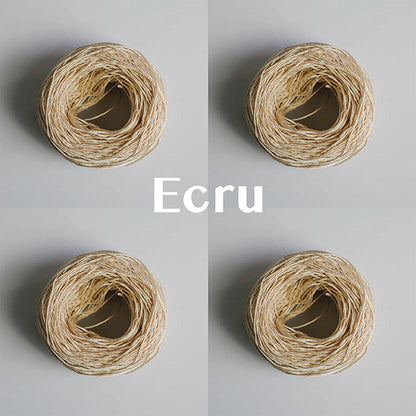 Four yarn cakes of 4-ply mercerised cotton yarn in ecru packaged in a compostable plastic bag and an Oxford Weaving Studio sticker