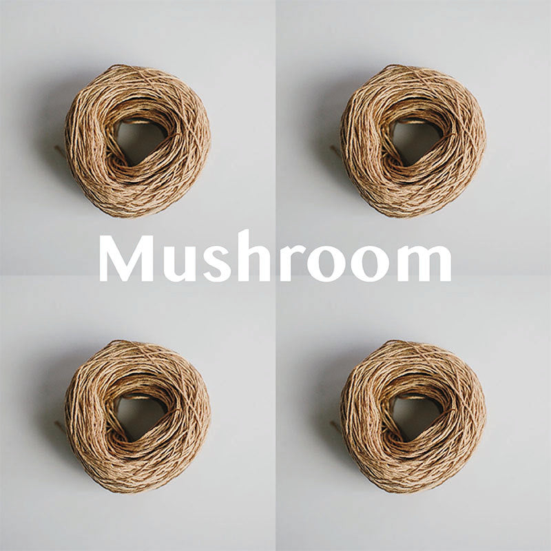 Four yarn cakes of 4-ply mercerised cotton yarn in mushroom packaged in a compostable plastic bag and an Oxford Weaving Studio sticker