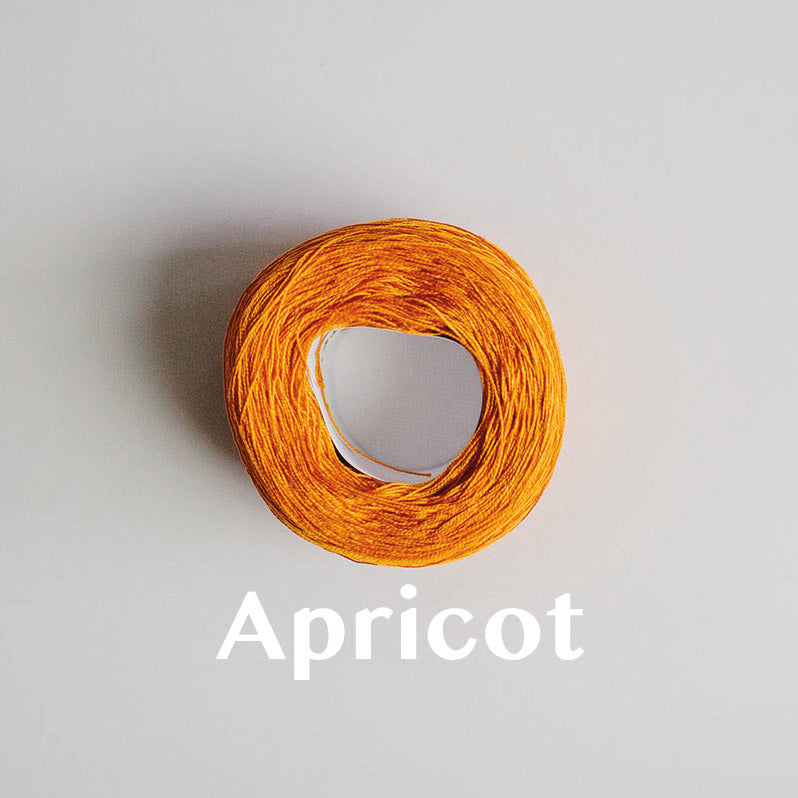 A 'Apricot' colour yarn cake of 2/16s mercerised cotton yarn