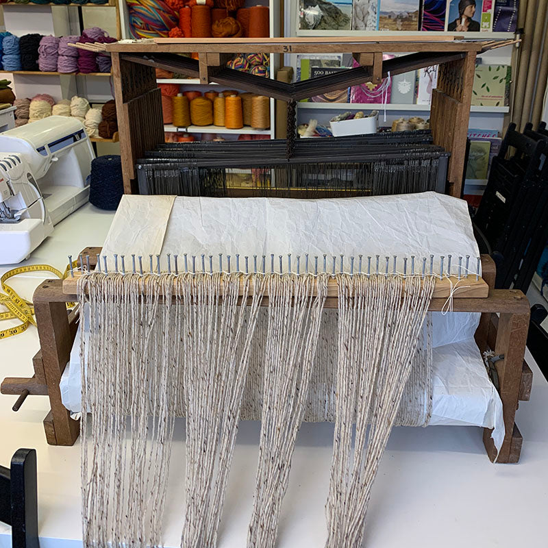 Warp yarn spaced evenly on a raddle on the back beam of a Harris table loom at Tools used in a Private Weaving workshop at The Oxford Weaving Studio