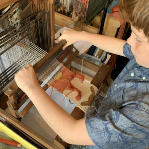Teen learning to weave Pokemon figures on a Harris table loom at The Oxford Weaving Studio